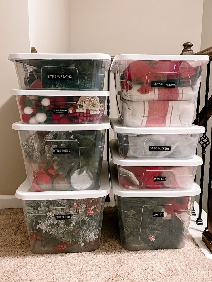 Plastic bins with neatly labeled Christmas decorations for organized holiday storage in a home closet.