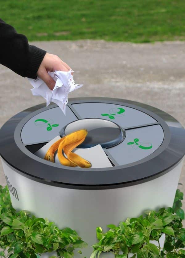 Hand tossing paper and banana peel into eco-friendly recycling bin.