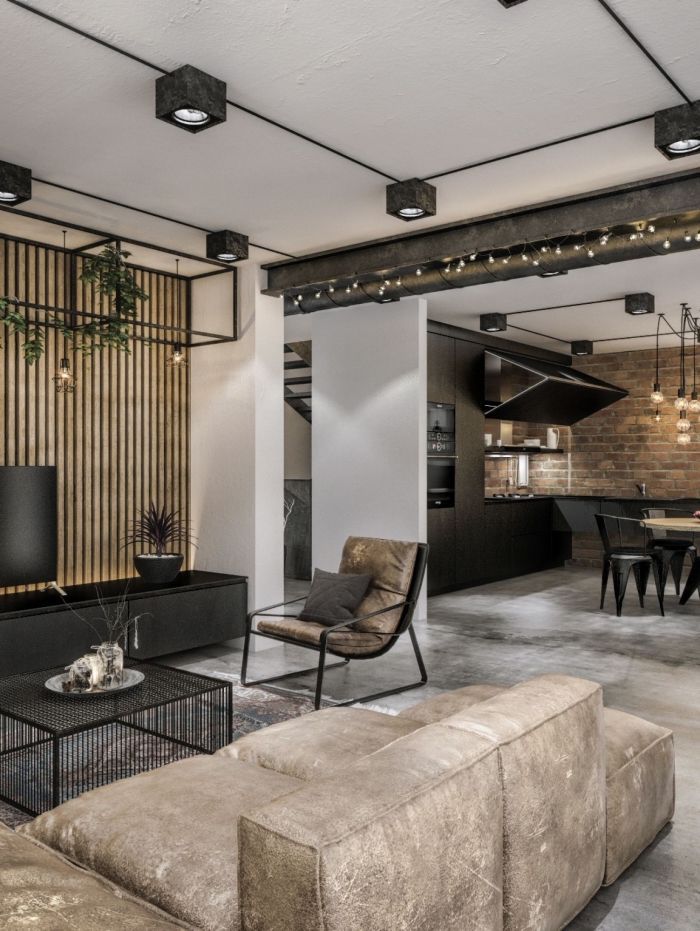 Modern industrial living room with beige sofa, exposed brick, and open kitchen design.