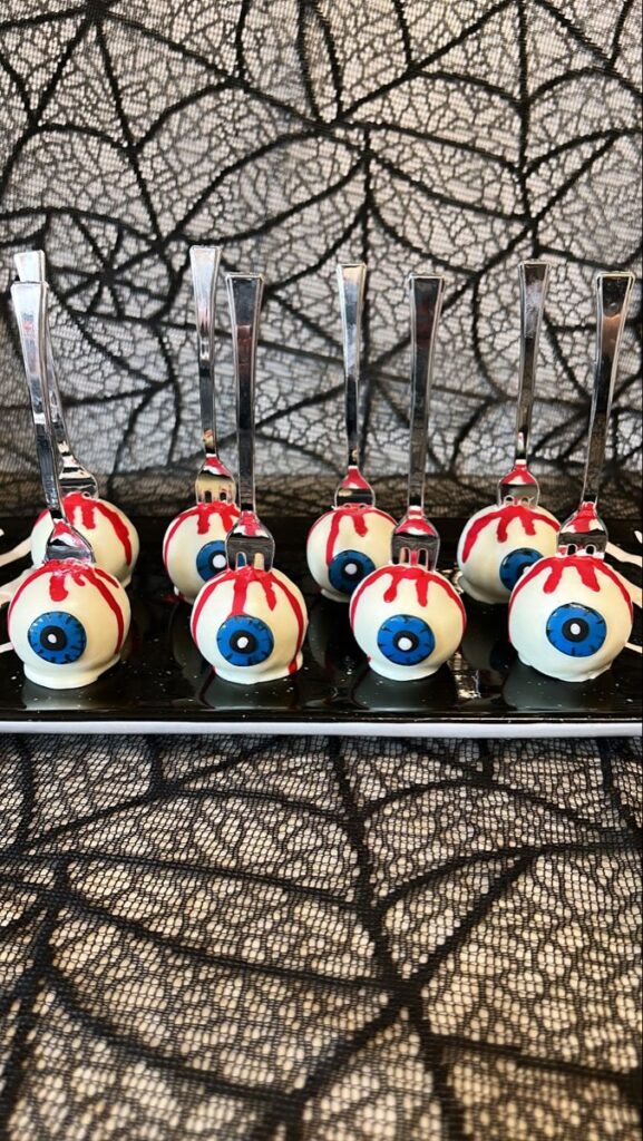 Eye ball cake pops Halloween eyeball cake pops on forks with a spooky black web background. | Sky Rye Design Halloween eyeball cake pops on forks with a spooky black web background.