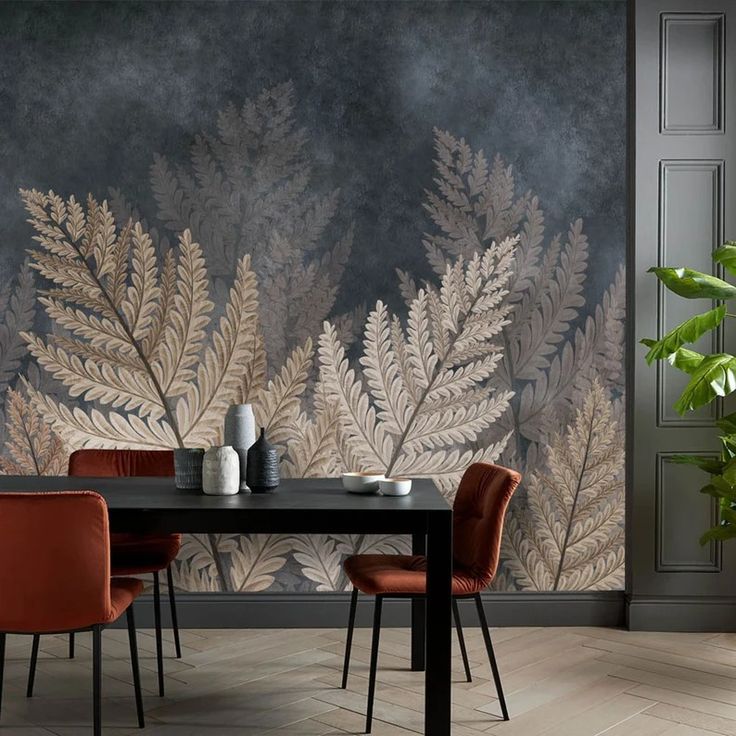 Modern dining room with dark table, red chairs, and botanical wallpaper featuring large fern leaves.