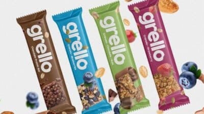 Grello snack bars in chocolate, blueberry, mint, and strawberry flavors with nuts and fruits surrounding them.