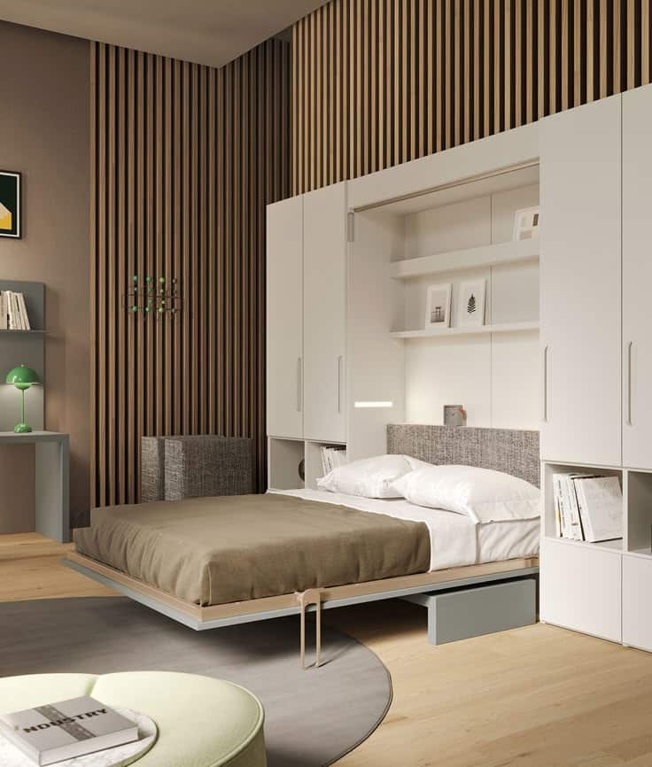 Modern room with a Murphy bed, white shelves, and wood paneling for stylish space-saving living.