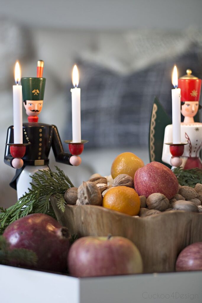German Influenced Christmas Home Tour Wooden candle holders with fresh fruits and nuts, festive centerpiece with glowing candles. | Sky Rye Design Wooden candle holders with fresh fruits and nuts, festive centerpiece with glowing candles.