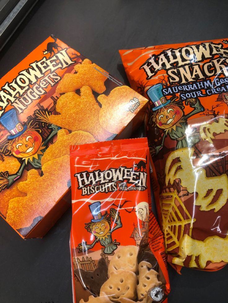 Halloween 🎃🍫🍟 Halloween-themed snacks on display: nuggets, biscuits, and snacks in festive orange packaging with spooky designs. | Sky Rye Design Halloween-themed snacks on display: nuggets, biscuits, and snacks in festive orange packaging with spooky designs.