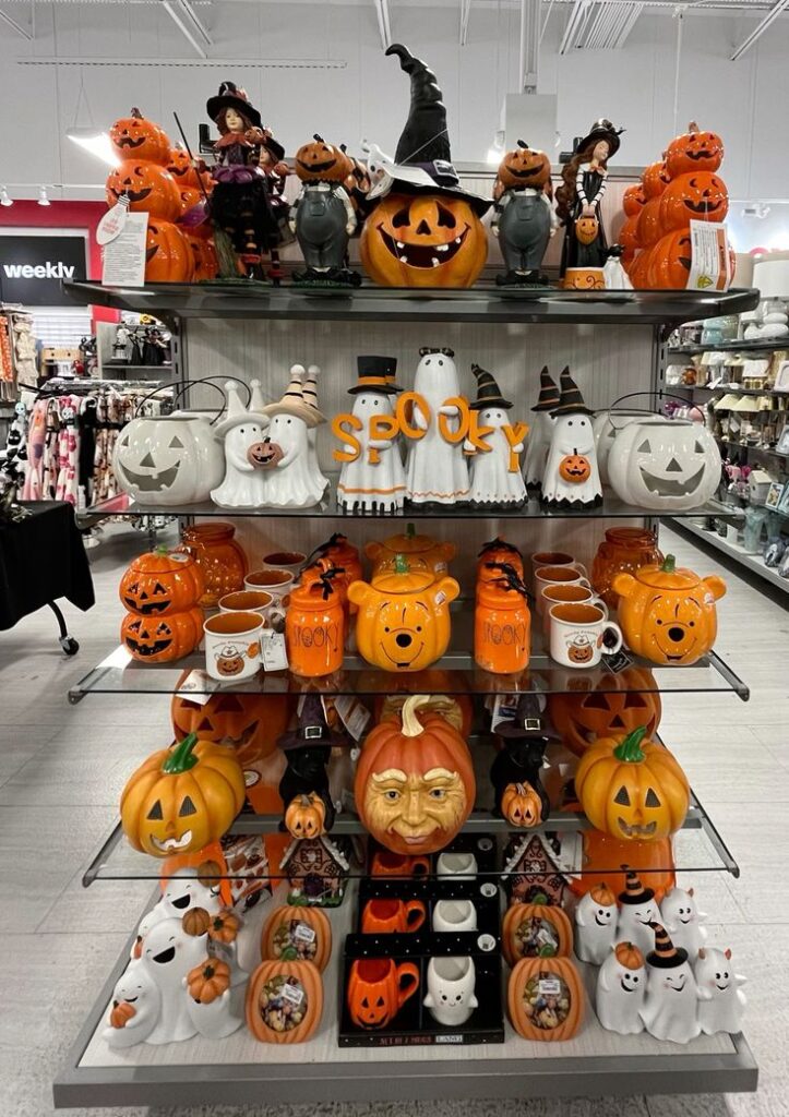 Halloween Visual merchandising home decor Spooky Halloween decor on store shelves with pumpkins, witch figurines, ghosts, and festive mugs. | Sky Rye Design Spooky Halloween decor on store shelves with pumpkins, witch figurines, ghosts, and festive mugs.