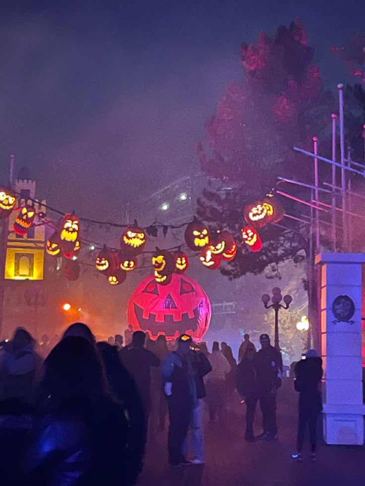 Halloween decorations with glowing jack-o'-lanterns and large pumpkin, creating a festive atmosphere at night.