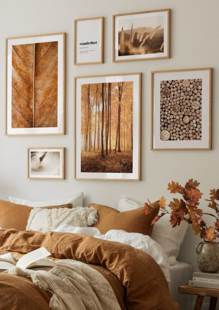 Cozy bedroom with autumn-themed wall art, neutral bedding, and decorative pillows for a warm, inviting atmosphere.