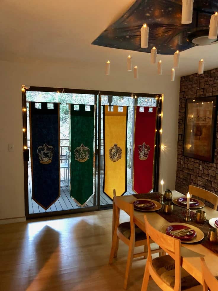Dining room with floating candles and colorful house banners creating a magical atmosphere.