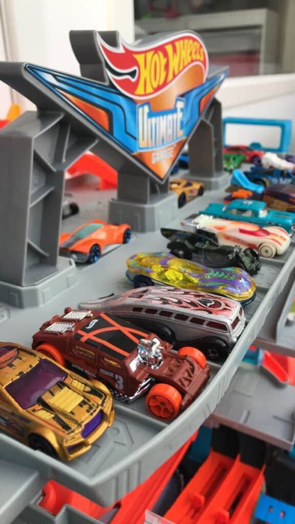 Colorful toy cars displayed on a Hot Wheels Ultimate Garage playset.