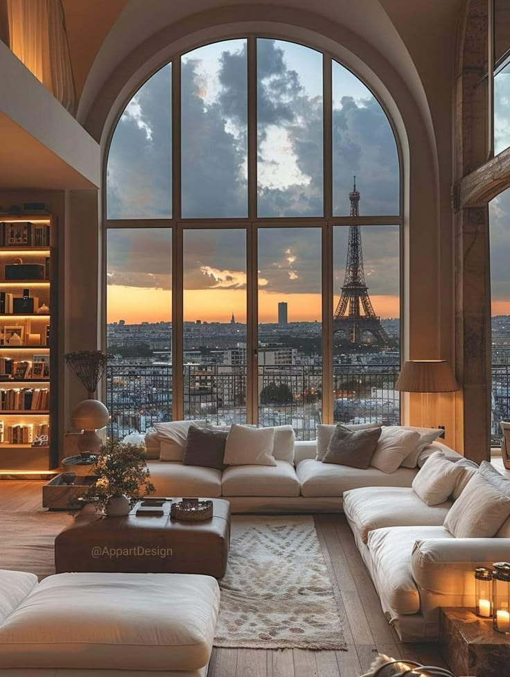 Luxurious living room with Eiffel Tower view through arched window at sunset, cozy sofas, and elegant decor.