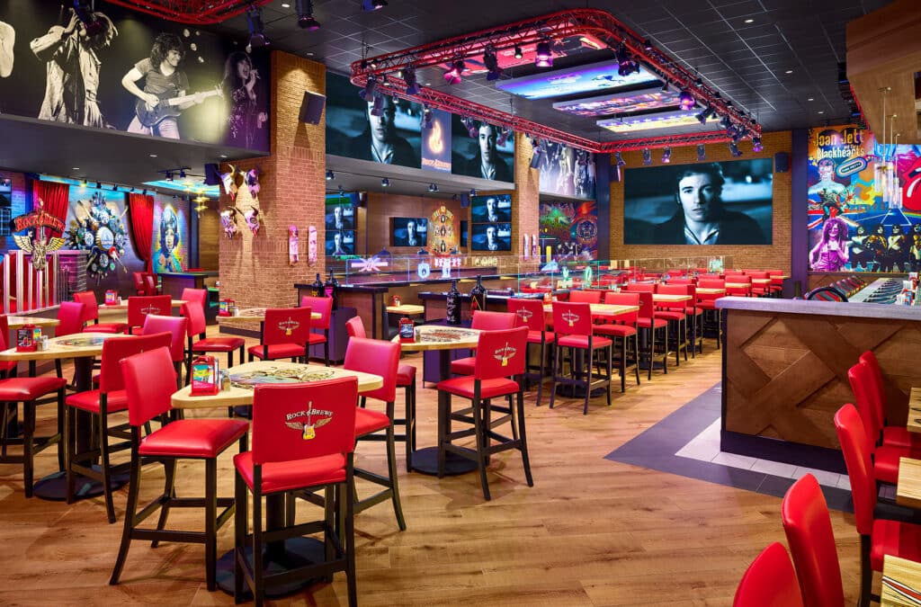 Vibrant rock-themed restaurant interior with red chairs, colorful walls, and music memorabilia.
