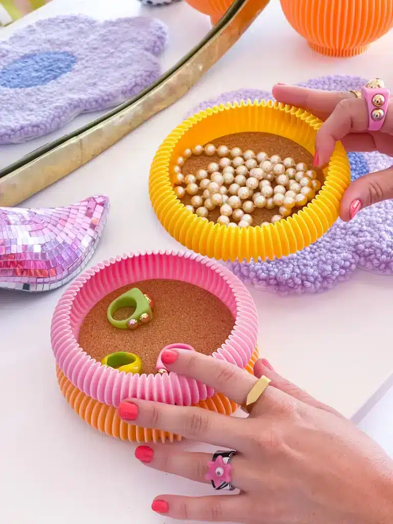 IMG_0401 Colorful ring and pearl storage bowls with decorative items and hands showcasing vibrant jewelry on a stylish surface. | Sky Rye Design Colorful ring and pearl storage bowls with decorative items and hands showcasing vibrant jewelry on a stylish surface.