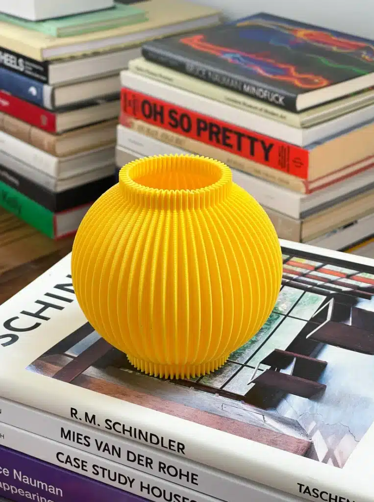 IMG_0538 Yellow ribbed vase on stacked architecture books, surrounded by colorful books. | Sky Rye Design Yellow ribbed vase on stacked architecture books, surrounded by colorful books.