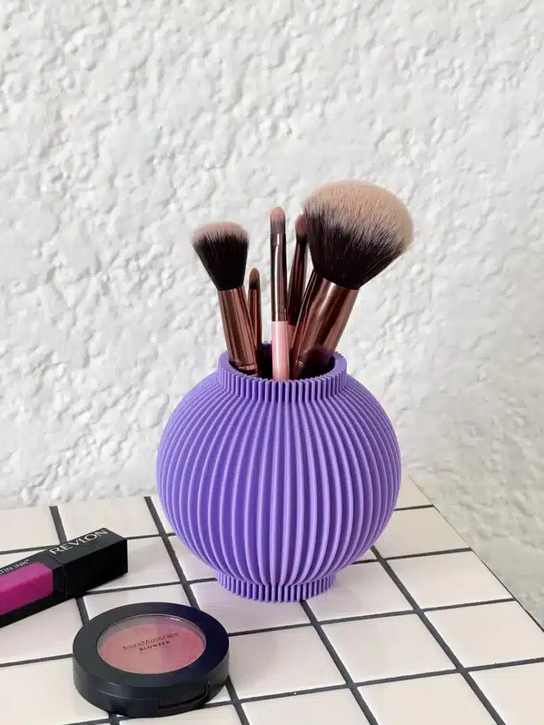 IMG_1340 Purple vase holding makeup brushes on a tiled surface with blush and lipstick nearby. | Sky Rye Design Purple vase holding makeup brushes on a tiled surface with blush and lipstick nearby.