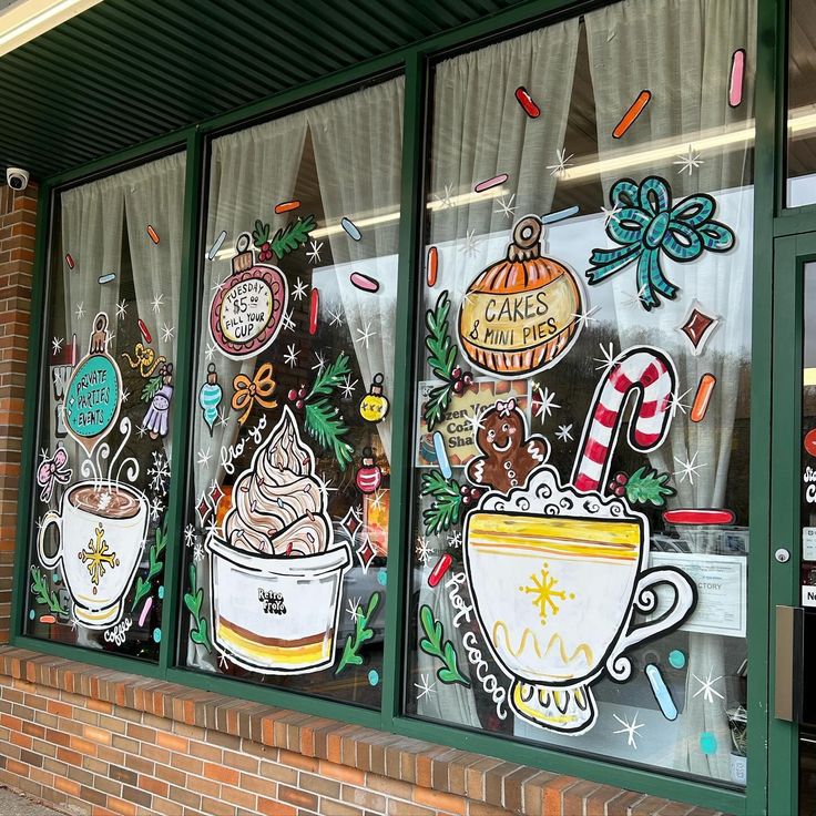 Festive cafe window with colorful holiday drawings of hot cocoa, desserts, and seasonal decorations.