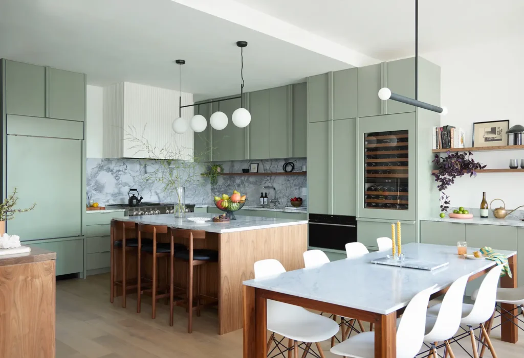 KQ-Feature-Photo Modern kitchen with green cabinets, marble countertops, wooden island, and stylish lighting fixtures. | Sky Rye Design Modern kitchen with green cabinets, marble countertops, wooden island, and stylish lighting fixtures.
