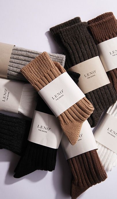 Assorted ribbed socks in neutral tones with LENO branding, including beige, brown, black, and grey pairs, neatly arranged.