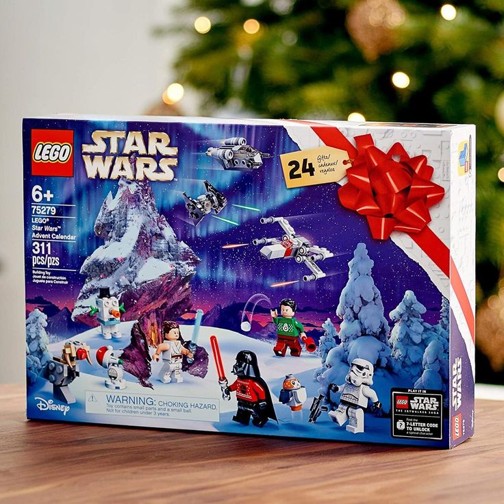 Lego Star Wars advent calendar box with festive bow, featuring characters and ships, set against a snowy backdrop.