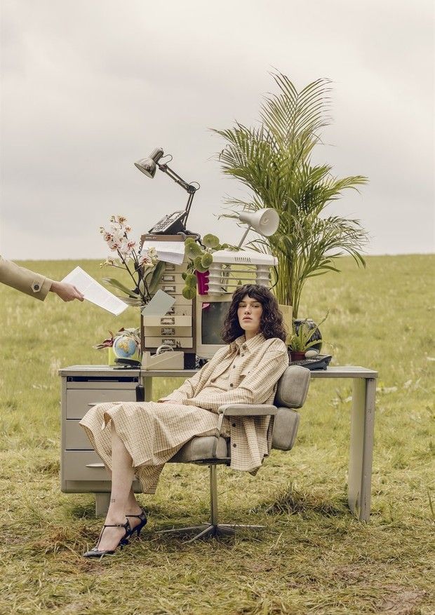LinkedIn da beleza_ conheça a plataforma que reúne vagas do mercado de beauté Woman in vintage office attire sits outdoors with plants, desk, and papers, blending nature with a retro workspace. | Sky Rye Design Woman in vintage office attire sits outdoors with plants, desk, and papers, blending nature with a retro workspace.