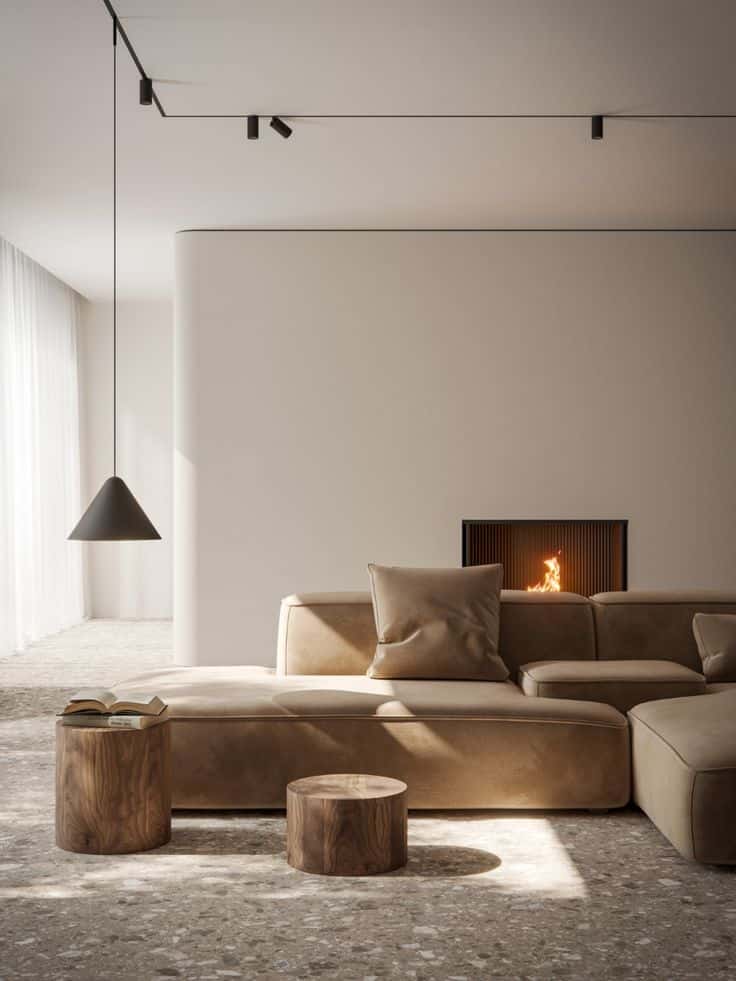 Modern living room with beige sectional sofa, minimalist decor, wood tables, pendant light, and a cozy fireplace.