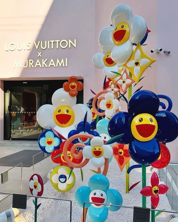Louis Vuitton x Takashi Murakami Pop-Up in Seoul Colorful flower sculptures outside Louis Vuitton x Murakami store display, showcasing vibrant art collaboration. | Sky Rye Design Colorful flower sculptures outside Louis Vuitton x Murakami store display, showcasing vibrant art collaboration.