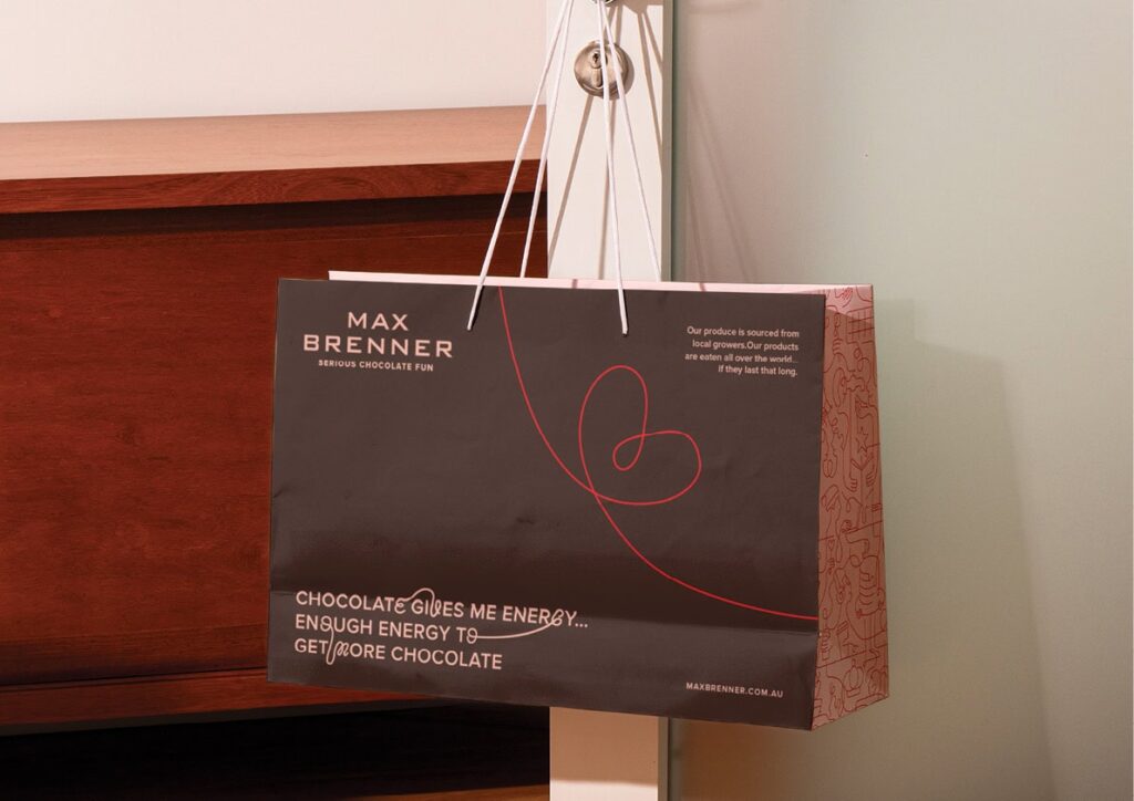Max-Brenner-Case-Study-202411 Max Brenner shopping bag hanging on a door, showcasing the brand's signature chocolate-themed design. | Sky Rye Design Max Brenner shopping bag hanging on a door, showcasing the brand's signature chocolate-themed design.