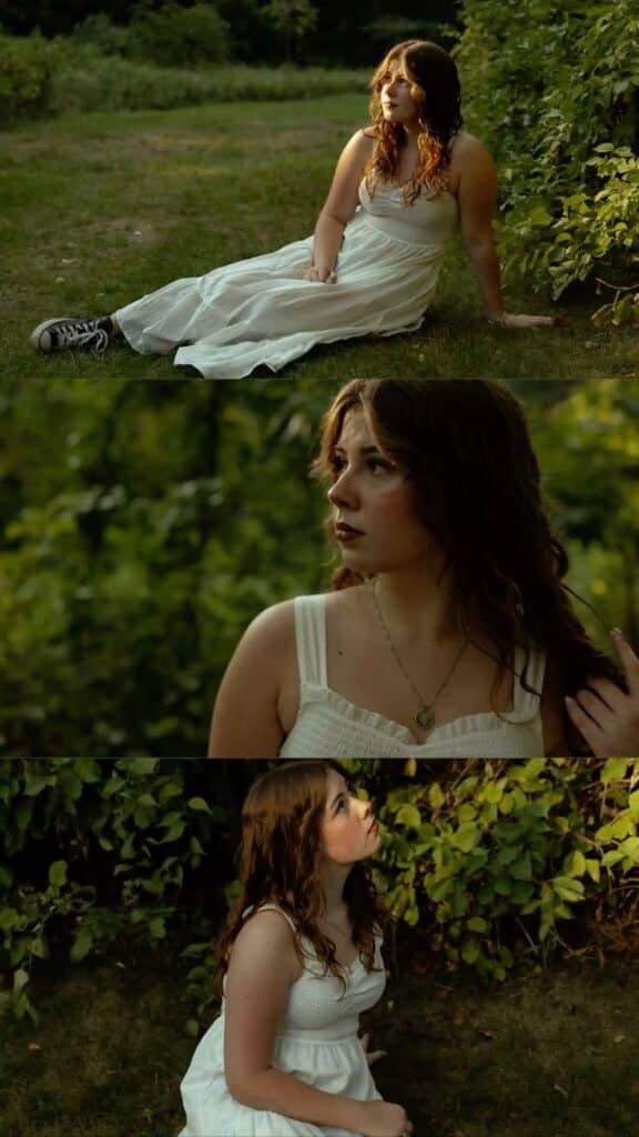 Young woman in a white dress sitting in a lush green garden, gazing thoughtfully into the distance.