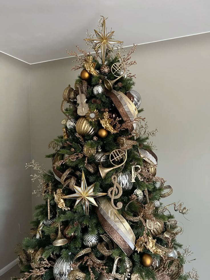 Luxurious Christmas tree adorned with gold musical instruments and star topper in a cozy living room setting.