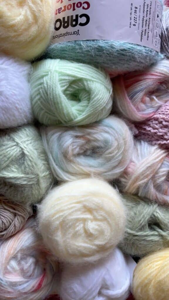 Colorful balls of yarn in pastel shades, ideal for knitting and crochet projects.