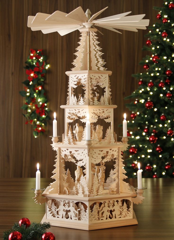 Original Weihnachtspyramiden aus dem Erzgebirge Wooden Christmas pyramid with lit candles, intricate carvings, and festive backdrop of decorated Christmas tree and wreath. | Sky Rye Design Wooden Christmas pyramid with lit candles, intricate carvings, and festive backdrop of decorated Christmas tree and wreath.