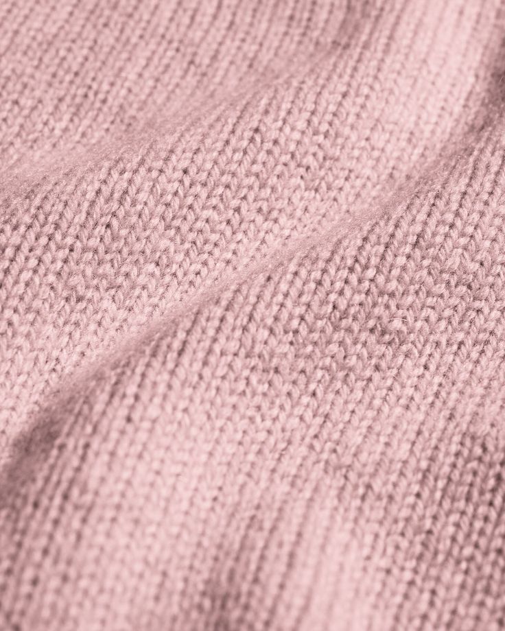 Close-up of pink knitted fabric texture, showcasing soft, cozy material details and weave pattern.
