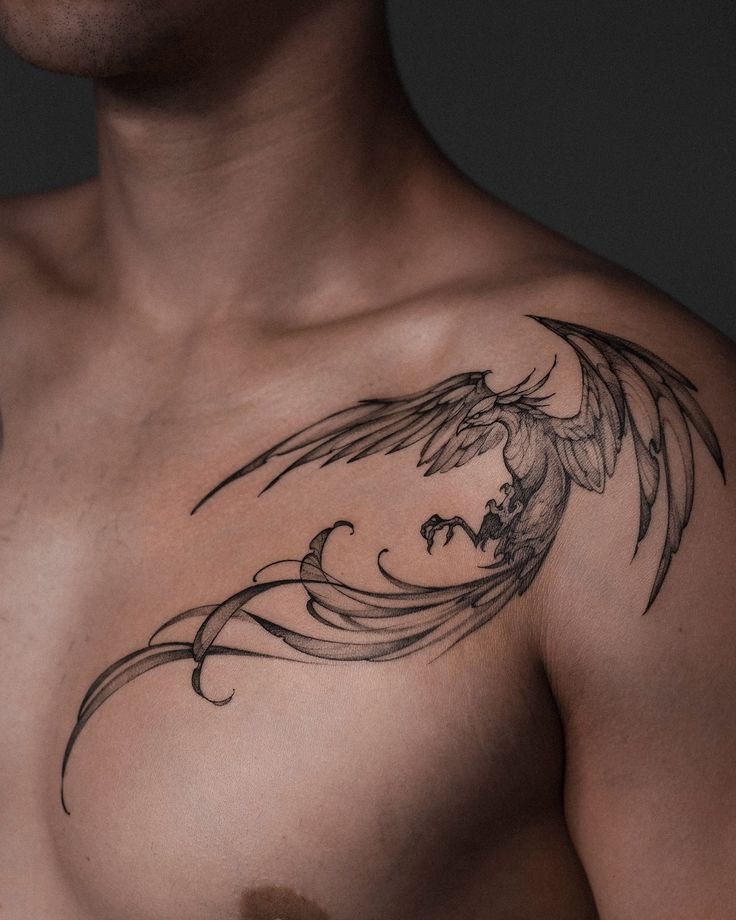 Stylish phoenix tattoo on a person's chest, featuring intricate black line art with detailed wing design.