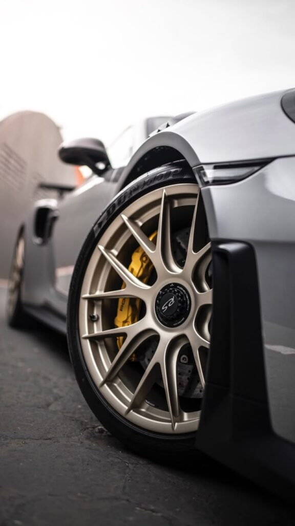 Close-up of a sports car wheel with sleek design and performance brake caliper.
