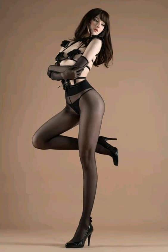 Fashion model in black lingerie and stockings, posing against a beige background, showcasing elegance and style.