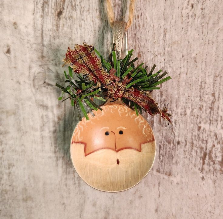 Primitive Balding Santa Ornament Painted Vintage Spoon Christmas Decor Spoon Ornament Hand Painted Country Christmas 13 Rustic Santa Claus ornament with festive ribbon and greenery on a wooden background. | Sky Rye Design Rustic Santa Claus ornament with festive ribbon and greenery on a wooden background.