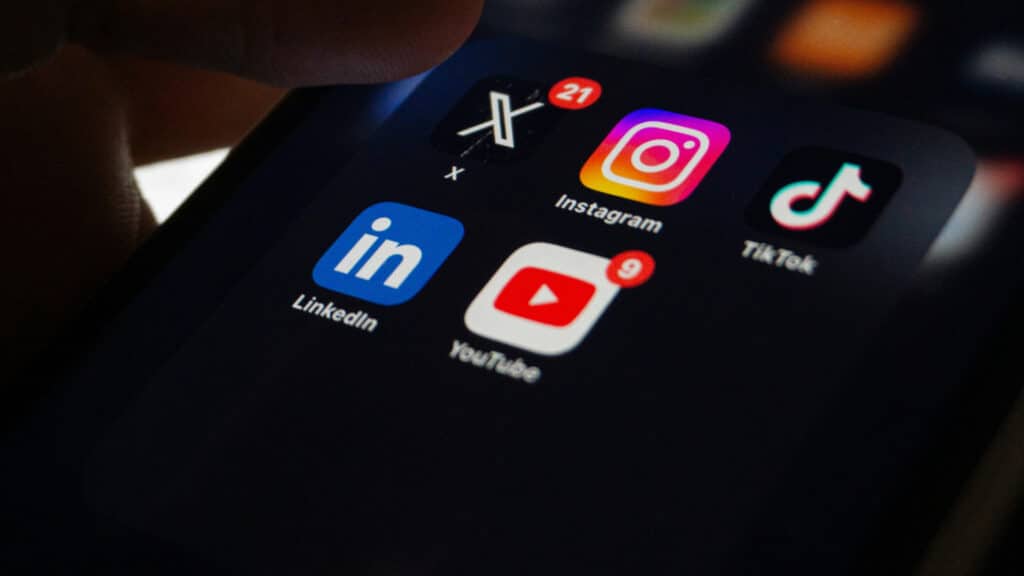 Pro Tip Close-up of a smartphone screen displaying social media app icons: X, Instagram, TikTok, LinkedIn, and YouTube notifications. | Sky Rye Design Close-up of a smartphone screen displaying social media app icons: X, Instagram, TikTok, LinkedIn, and YouTube notifications.