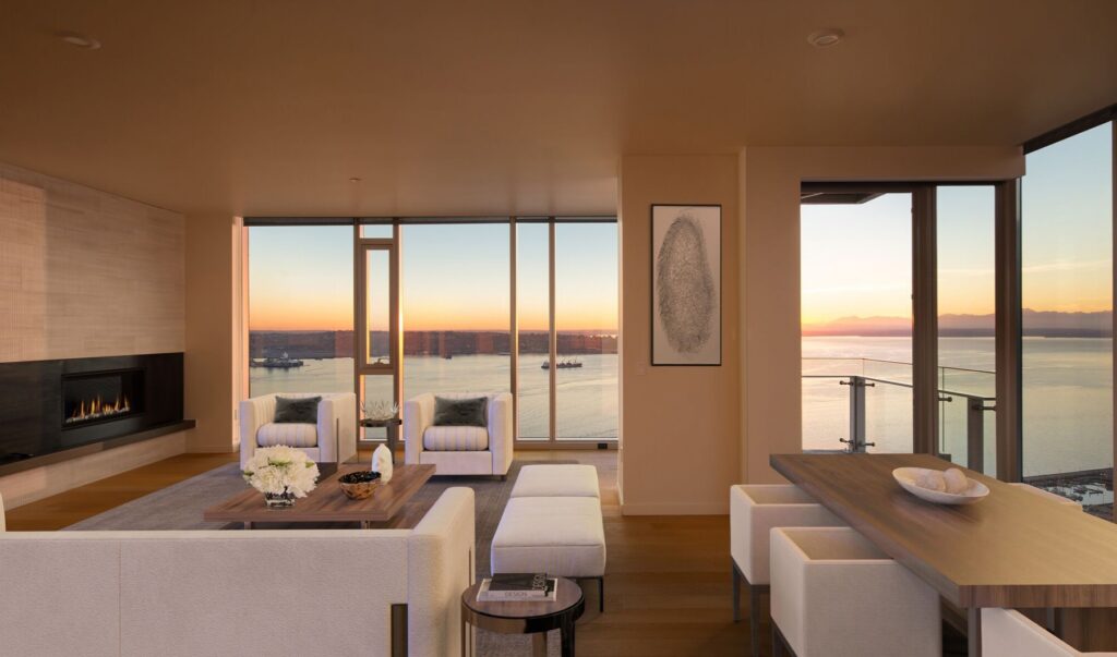 Rotator-2-080d50d0b627af28f3726d837d242213 Modern living room with ocean view at sunset, featuring elegant furniture and a cozy fireplace. | Sky Rye Design Modern living room with ocean view at sunset, featuring elegant furniture and a cozy fireplace.