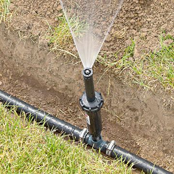 Sprinkler system in operation on a lawn, showcasing efficient irrigation setup for healthy grass maintenance.