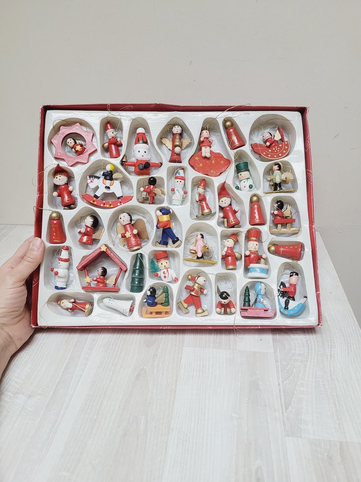 Set of 36 German Erzgebirge hanging ornament angel Santa snowman horse Vintage Christmas dolls wooden Figurine Retro made in Germany DDR Box of assorted wooden Christmas ornaments featuring festive characters and shapes. | Sky Rye Design Box of assorted wooden Christmas ornaments featuring festive characters and shapes.