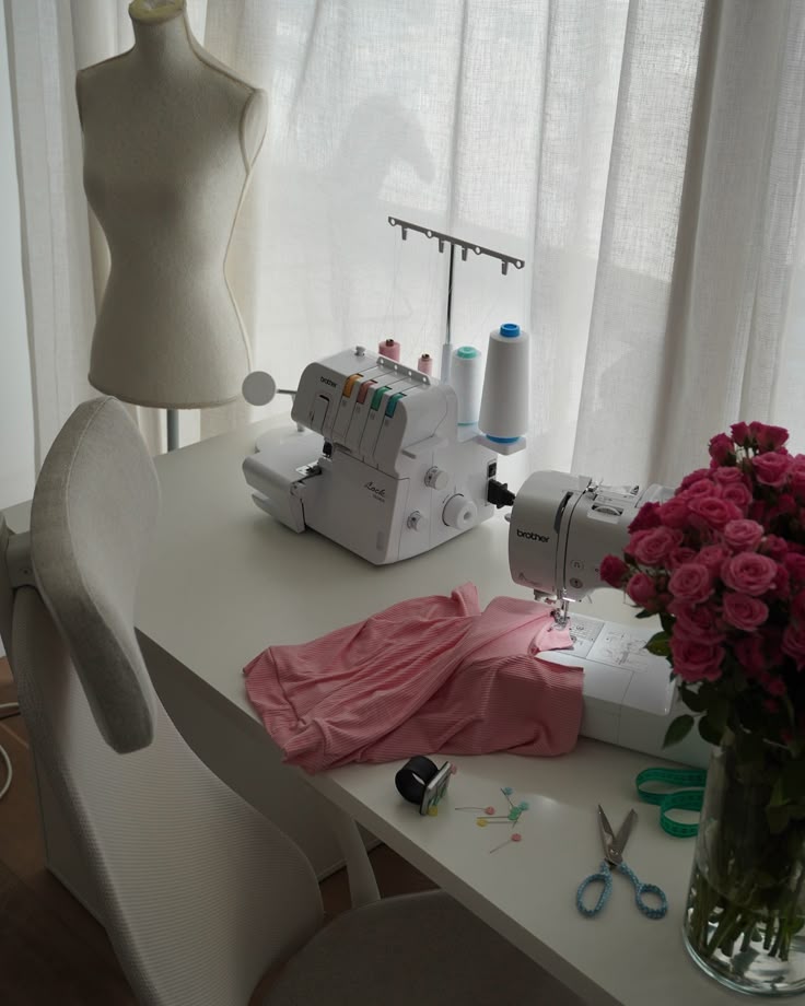 Sewing station with serger, dress form, and bouquet of roses, ideal for fashion and design projects.
