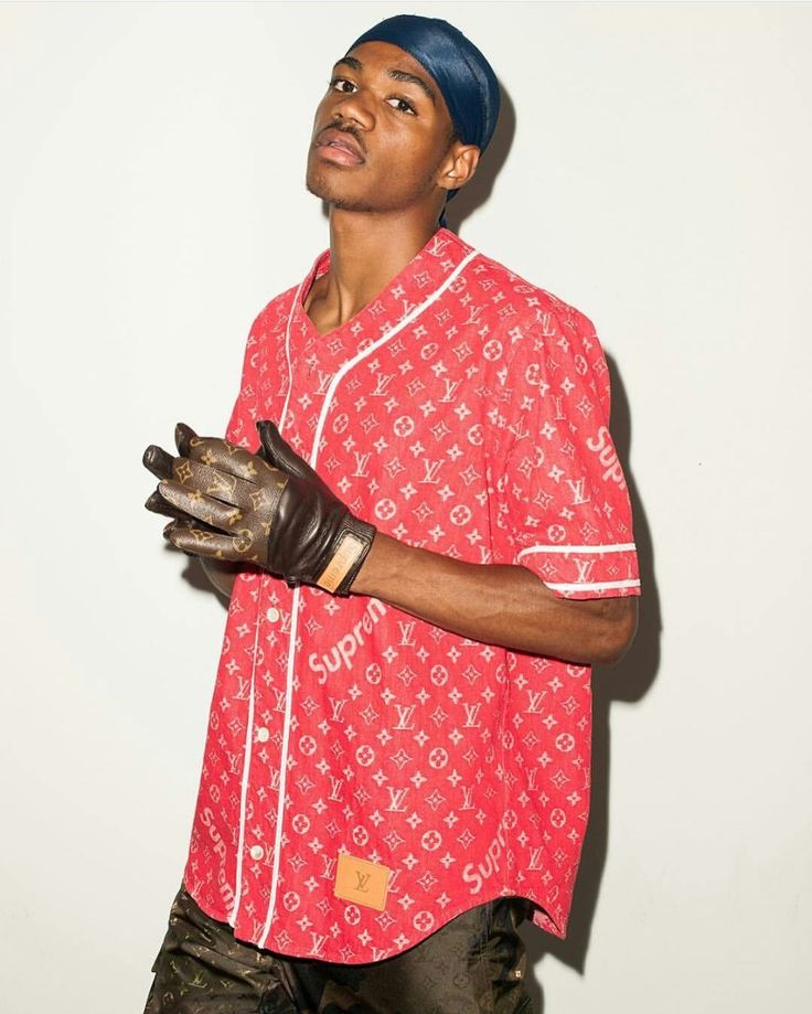 Supreme x Louis Vuitton Release Man in red Supreme x Louis Vuitton shirt with black gloves and navy headscarf, posing stylishly against a white background. | Sky Rye Design Man in red Supreme x Louis Vuitton shirt with black gloves and navy headscarf, posing stylishly against a white background.