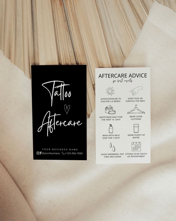 Black and white tattoo aftercare cards with care instructions on fabric background.