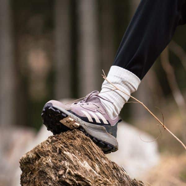 Trail running shoe on a log, showcasing grip and outdoor performance.