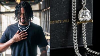 Man wearing silver chain indoors; close-up of silver chain with lion pendant on black background.