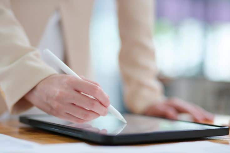 Top 7 Free Workflow Management Software Options Person using a stylus on a tablet screen for digital drawing or writing, showcasing modern technology in a workspace. | Sky Rye Design Person using a stylus on a tablet screen for digital drawing or writing, showcasing modern technology in a workspace.