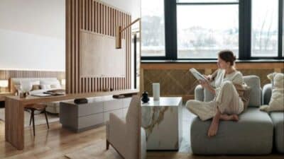 Modern living space with wood accents, cozy seating, large windows, and a person reading on a sofa.