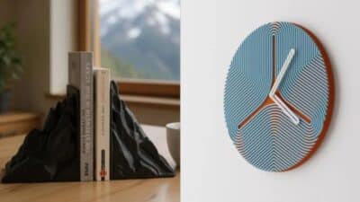 Mountain-shaped bookends with books next to a modern blue clock on a white wall. Minimalistic home decor.