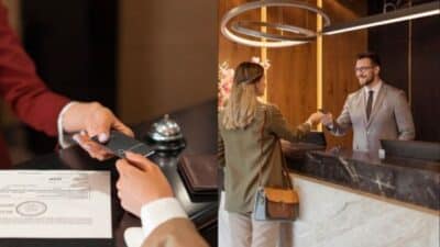 Hotel guest checking in at the reception desk, receiving a room key card from the receptionist in a modern lobby.