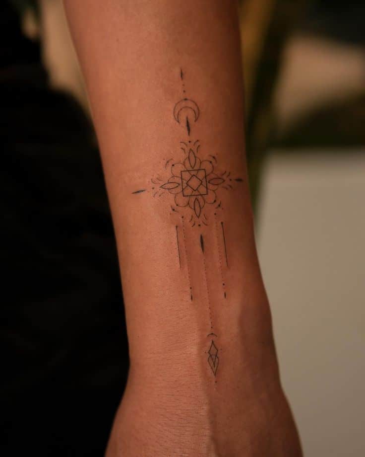 Geometric tattoo with crescent moon and intricate patterns on forearm, minimalist design.